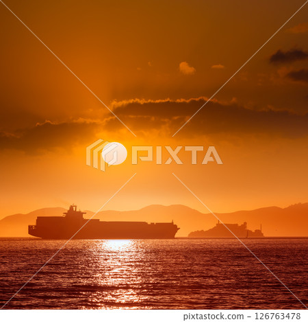 Alcatraz island penitentiary at sunset and merchant ship Alcatraz island penitentiary at sunset and merchant ship 126763478