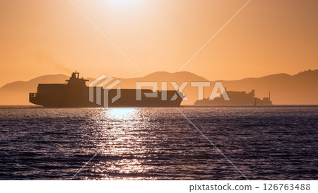 Alcatraz island penitentiary at sunset and merchant ship Alcatraz island penitentiary at sunset and merchant ship 126763488