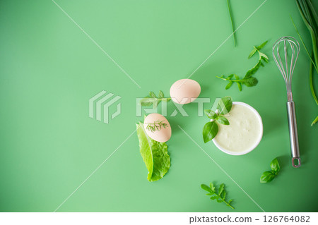 homemade egg mayonnaise with herbs in a bowl on a green background 126764082