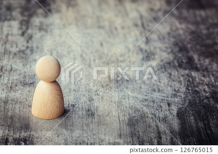 Simple wooden figure on textured surface 126765015