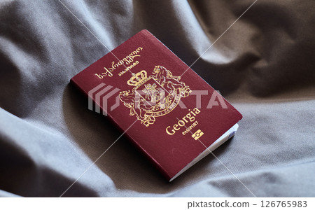 A Georgia passport displayed on a soft gray surface 126765983