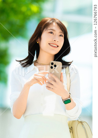 Woman/businesswoman using smartphone outdoors 126766793