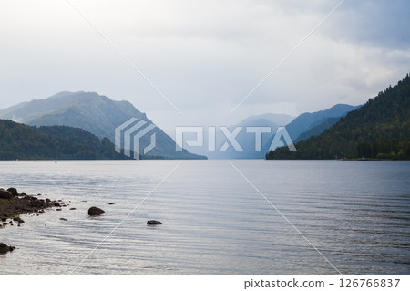 Calm lake nestled between forested mountains, Altai landscape Calm lake nestled between forested mountains, Altai landscape 126766837