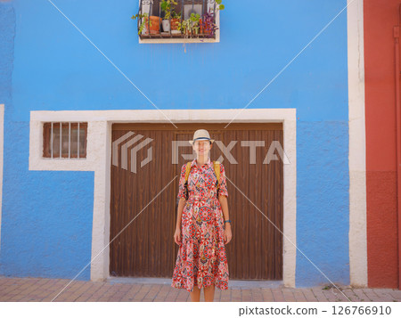 Woman strolls through colorful streets of Spanish coastal town 126766910