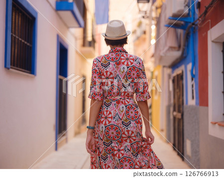 Woman strolls through colorful streets of Spanish coastal town Woman strolls through colorful streets of Spanish coastal town 126766913