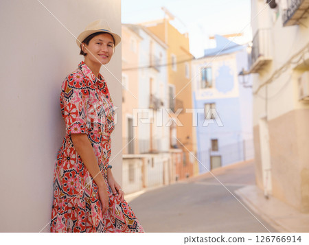 Woman strolls through colorful streets of Spanish coastal town 126766914
