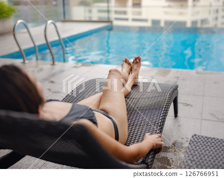 Young woman relaxing by the pool at a Kuala Lumpur hotel 126766951