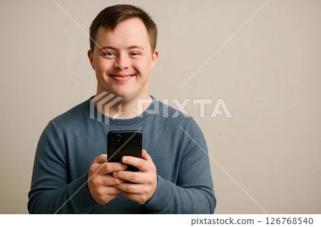 Portrait of Young Man with Down Syndrome Holding Phone Portrait of Young Man with Down Syndrome Holding Phone 126768540