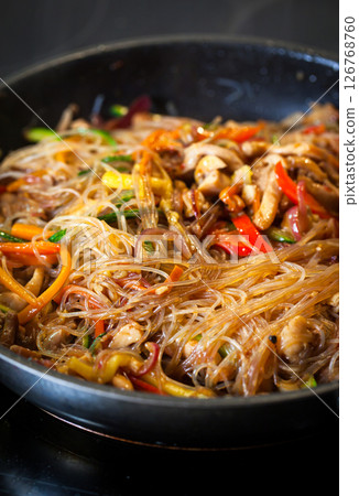 Asian glass noodle stir-fry with chicken and vegetables in a rustic ceramic bowl Asian glass noodle stir-fry with chicken and vegetables in a rustic ceramic bowl 126768760