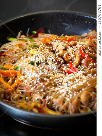 Asian glass noodle stir-fry with chicken and vegetables in a rustic ceramic bowl Asian glass noodle stir-fry with chicken and vegetables in a rustic ceramic bowl 126768761