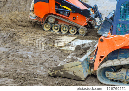 Heavy machinery works on wet ground to prepare construction site for building development under works day Heavy machinery works on wet ground to prepare construction site for building development under works day 126769251