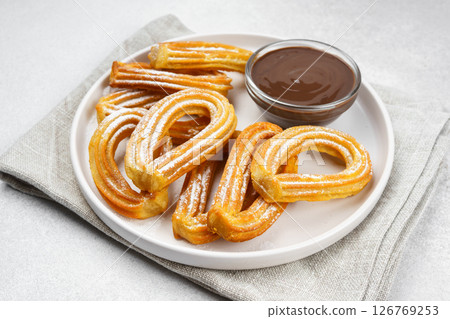 Traditional spanish dessert churros, fried dough pastry and chocolate sause on white background Traditional spanish dessert churros, fried dough pastry and chocolate sause on white background 126769253