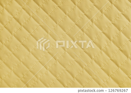 Checkered, diamond stitching pattern, yellow quilted fabric background. Blanket stitch texture 126769267
