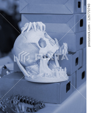 A prototype of a human skull printed on a 3D printer from molten plastic. Skeleton human head created on 3D printer. New additive 3D printing. 3D printing modern technology. FDM printing technology 126770740