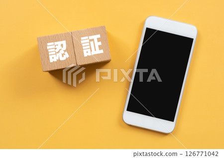A block with the word "authentication" written on it and a smartphone 126771042