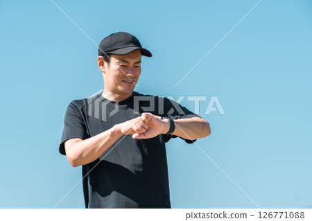 A middle-aged man in sportswear using a smart watch, pedometer, and step counter to manage his health and health care 126771088