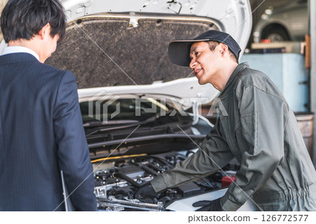男性汽車修理工（機械師、服務工程師、機械師）聽取服務前台人員的命令 126772577