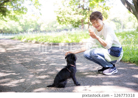 A Japanese woman training a dog 126773318