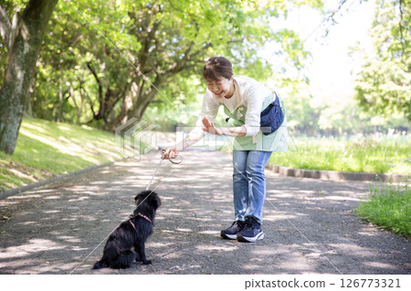 A Japanese woman training a dog 126773321