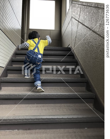 A boy desperately climbing the stairs 126773636
