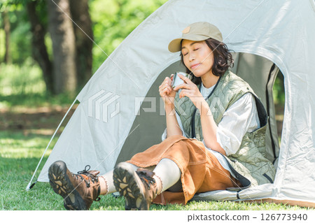 Woman enjoying camping glamping relaxing at campsite 126773940