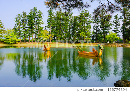 A boat floating among green trees 126774894