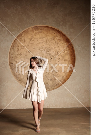 An Elegant Model Posing Gracefully Against a Unique Striking Geometric Background 126775236