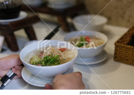 pho soup Vietnamese Vermicelli Soup Making Process Vietnam pho bo seller preparing rice vermicelli soup on the street small eatery cooking fa soup in Vietnam street food dirt unsanitary 126775681