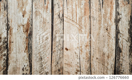 Weathered wooden planks with rustic aged texture in natural brown and beige tones forming a vertical wooden surface with visible grain knots cracks and rough imperfections in an old outdoor setting Weathered wooden planks with rustic aged texture in natural brown and beige tones forming a vertical wooden surface with visible grain knots cracks and rough imperfections in an old outdoor setting 126776660
