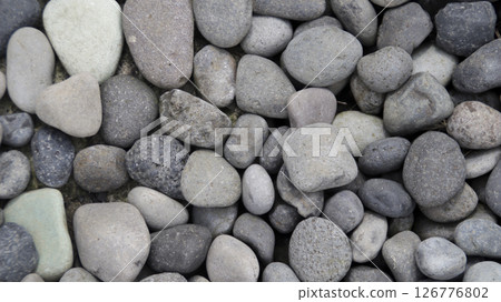 Closeup of Smooth Natural River Stones in Varied Shades of Gray and Brown Arranged on a Textured Outdoor Surface Closeup of Smooth Natural River Stones in Varied Shades of Gray and Brown Arranged on a Textured Outdoor Surface 126776802