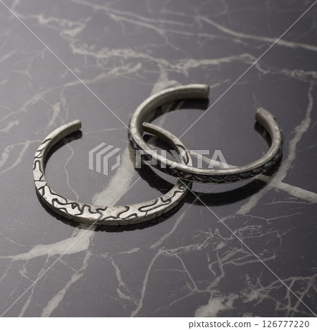Silver bangles set on black marble 126777220