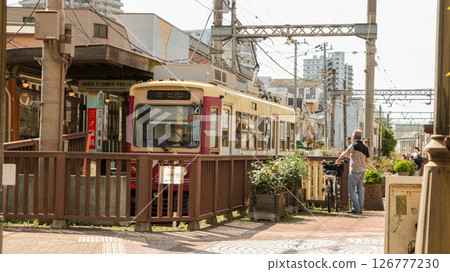 A retro Showa-era streetscape with a streetcar running 126777230