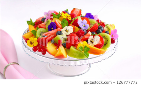 Fruit salad decorated with edible flowers 126777772