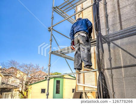 Worker repairing the exterior walls of a detached house 126778266