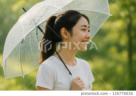 Young Japanese woman with umbrella posing in profile in natural light 126778838