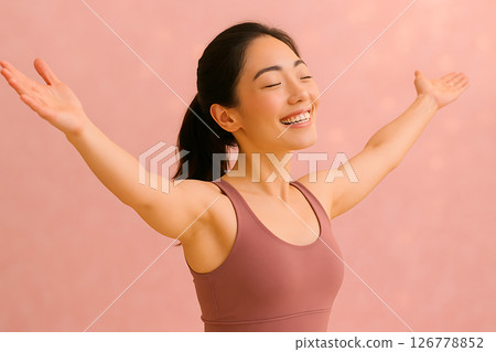 一位身著瑜珈服的日本女子張開雙臂微笑（粉紅背景） 126778852