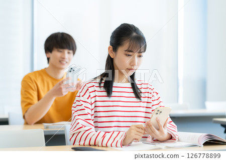 Male and female university students studying. Photo courtesy of Denpa Gakuen Tokyo Electronics College. 126778899