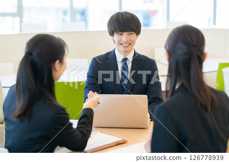 Male and female businessmen having a meeting. Photo courtesy of Denpa Gakuen Tokyo Electronics College. 126778939