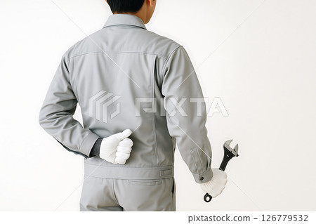 Back view of a Japanese male manufacturing worker holding an adjustable wrench and making a thumbs up gesture 126779532