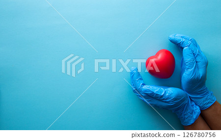 Hand in medical glove hold red heart sign. Hand in medical glove hold red heart sign. 126780756