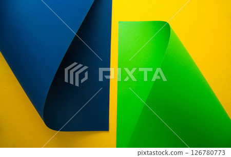 Vibrant blue and green paper shapes contrasted against a yellow background in a minimalist design Vibrant blue and green paper shapes contrasted against a yellow background in a minimalist design 126780773