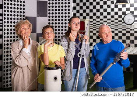 Kids and grandparents thinking about conundrum solution in escape room 126781017
