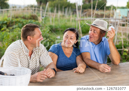 Happy farmers talking at village table 126781077