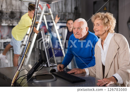 Senior man and woman with grandkids in escape room 126781080