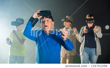 Astonished old man playing VR games with his family 126781096