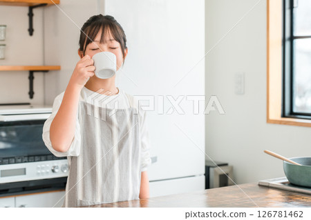 小學和國中女生穿著圍裙在廚房喝熱飲 126781462
