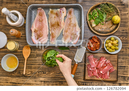 Preparing a flavorful dish with fresh ingredients on a wooden kitchen table Preparing a flavorful dish with fresh ingredients on a wooden kitchen table 126782094