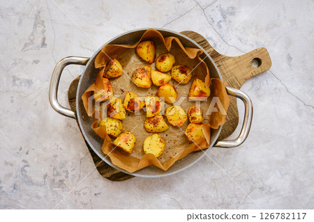 Crispy roasted potatoes arranged on a serving platter with a golden brown finish in bright light Crispy roasted potatoes arranged on a serving platter with a golden brown finish in bright light 126782117