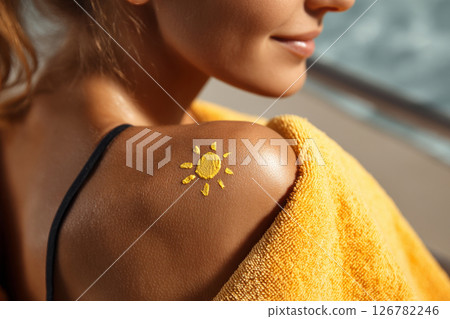 Sun drawn with sunscreen on tanned female shoulder 126782246