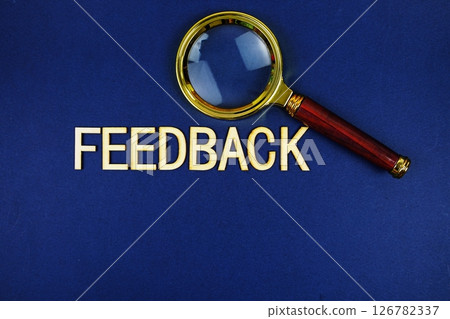 Feedback alphabet letters with magnifying glass on navy blue background Feedback alphabet letters with magnifying glass on navy blue background 126782337